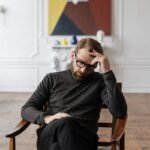 Man in Black Sweater Sitting on Brown Wooden Chair